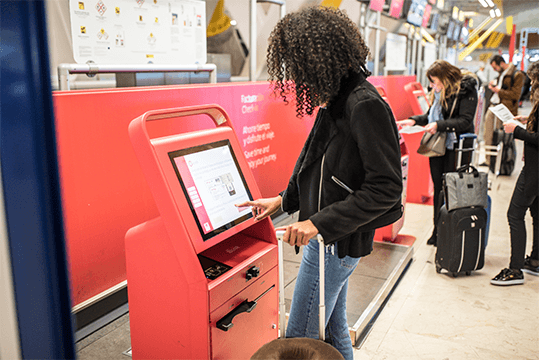 woman using check in kiosk at airport