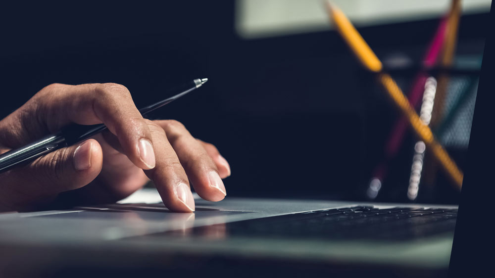 A closeup of hand on a laptop.