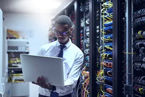 A man with a computer in an IT room.