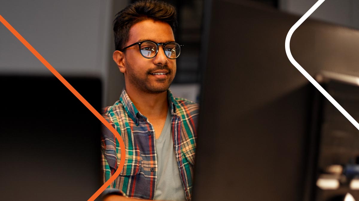 A man working at a desk with two monitors.