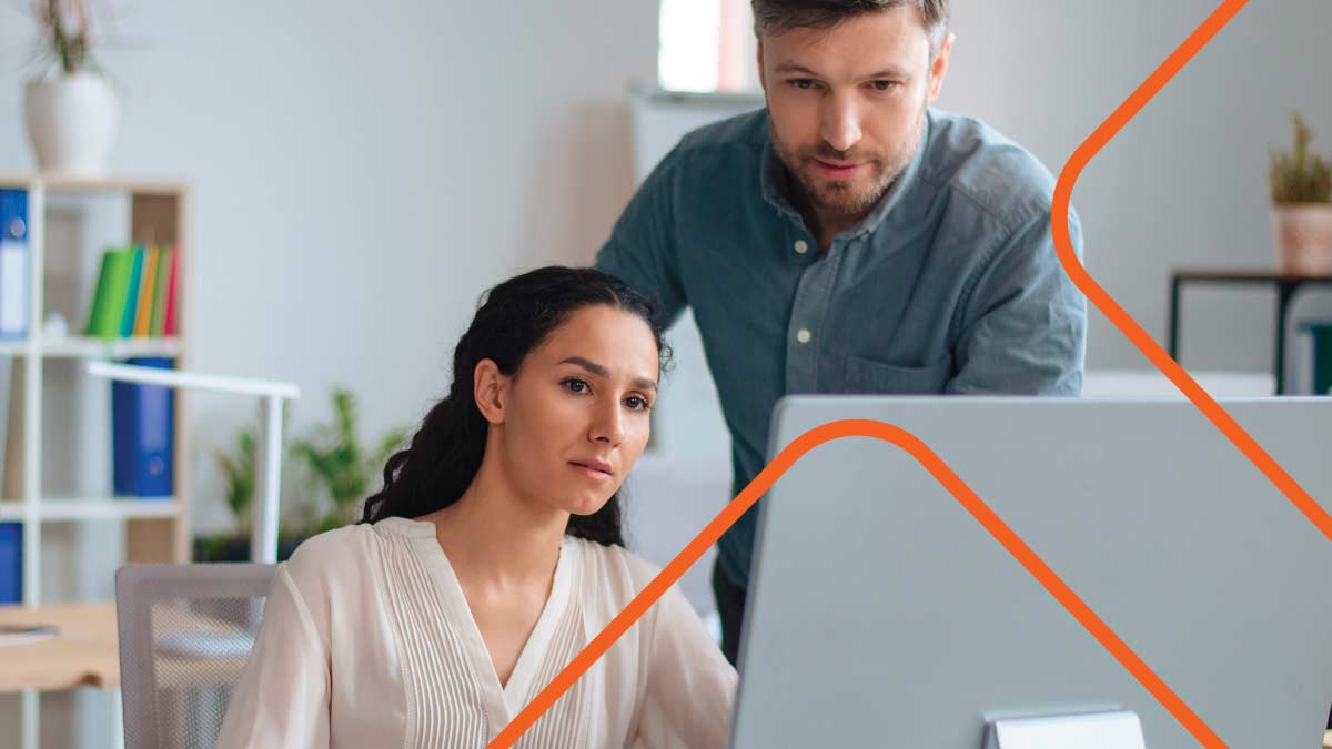 Man and woman looking at computer monitor on desk