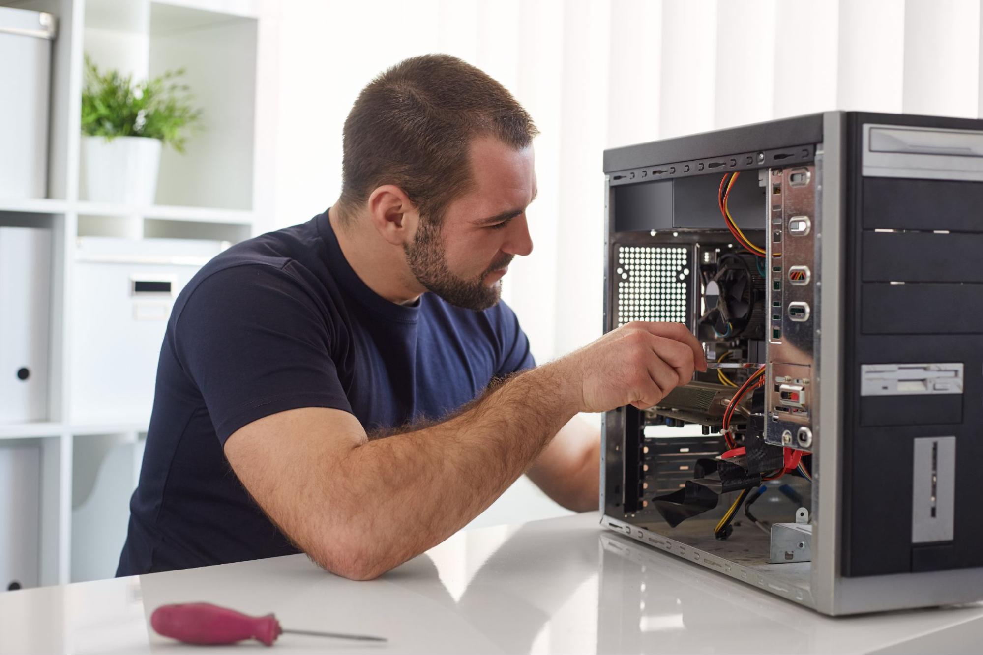 Man in blue t-shirt working on computer