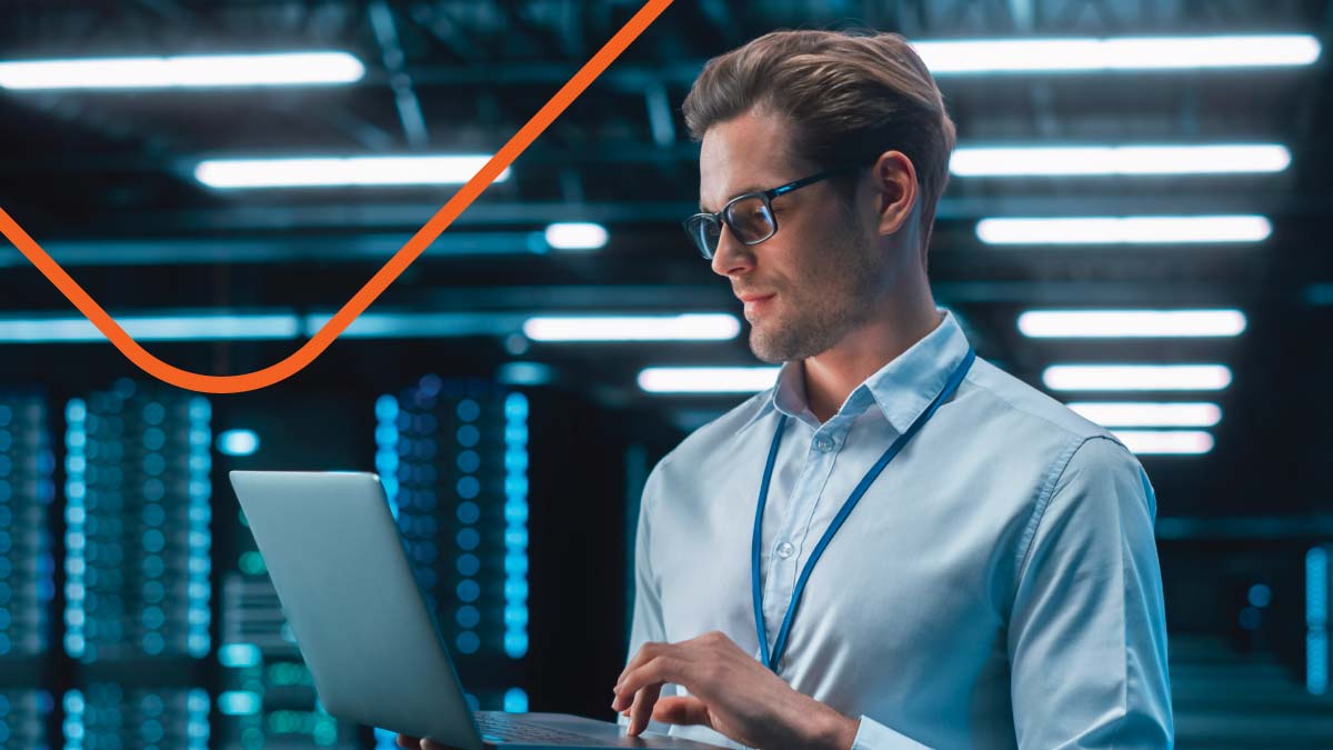 Man in light blue shirt working in server room