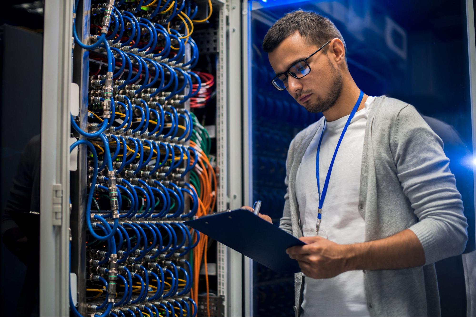 Man wearing glasses working with blue cabling