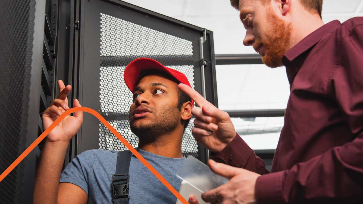 Two men examining server rack in datacenter