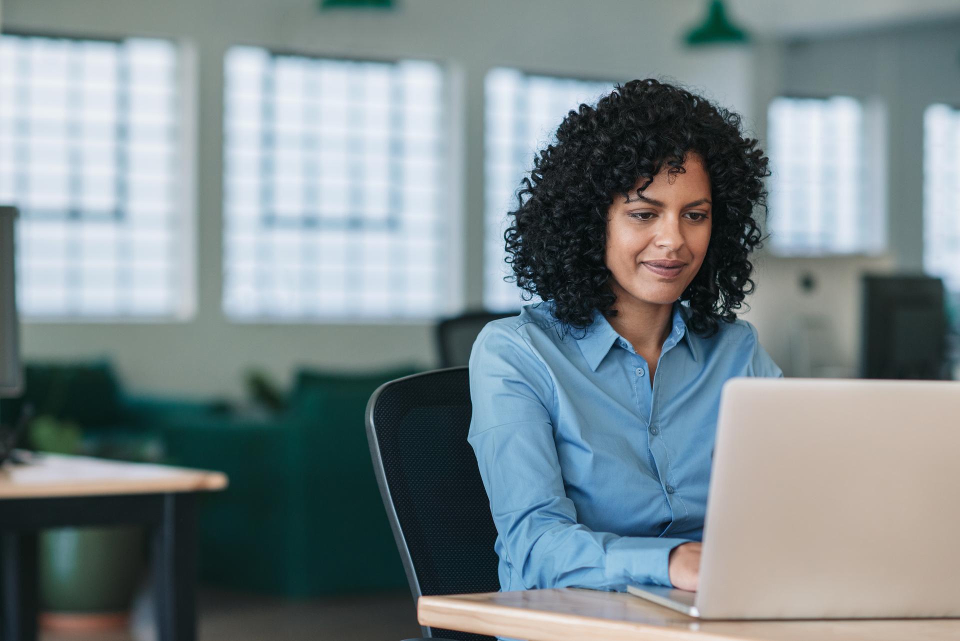 Woman at office desk using laptop