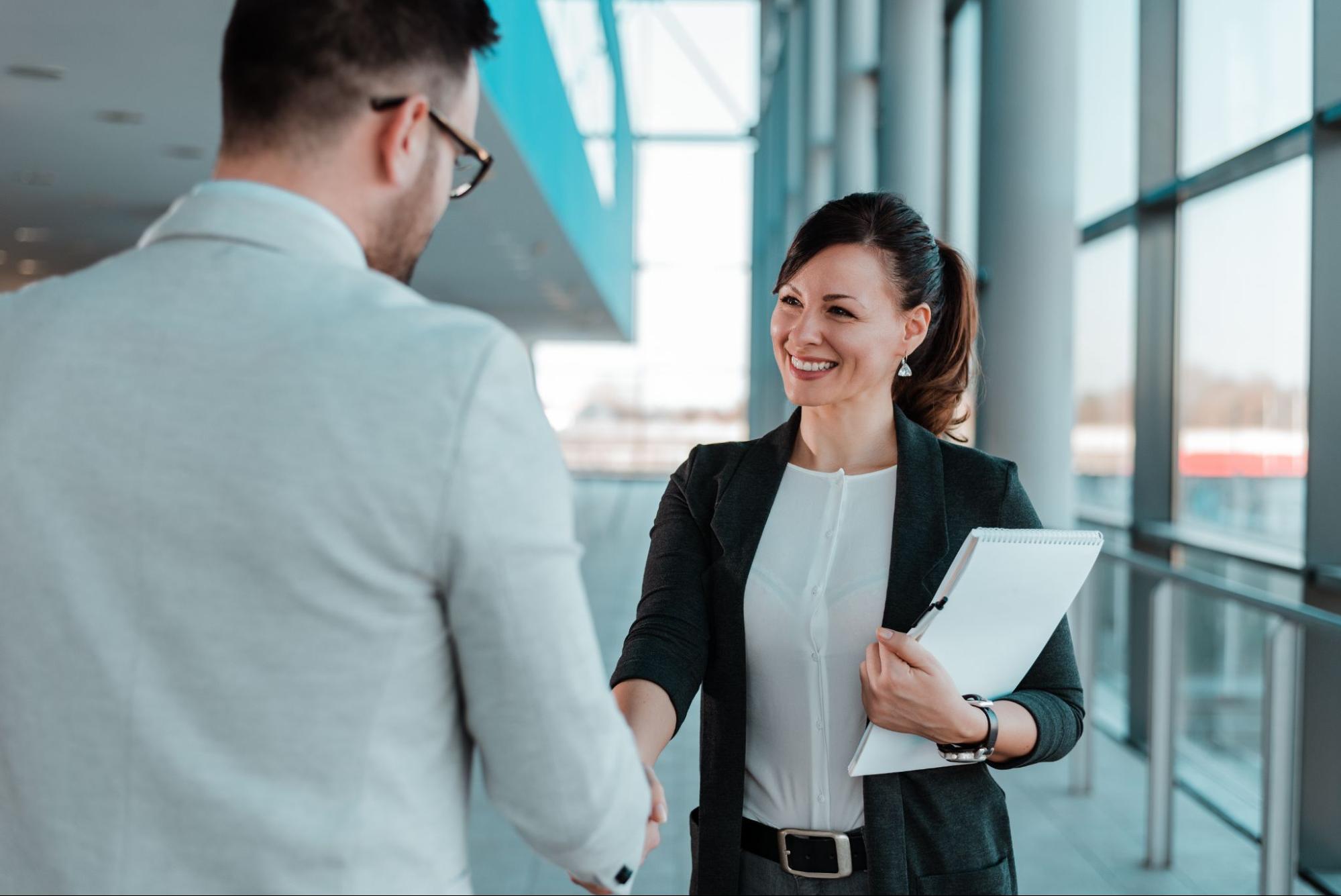 Woman shaking hands with man in office