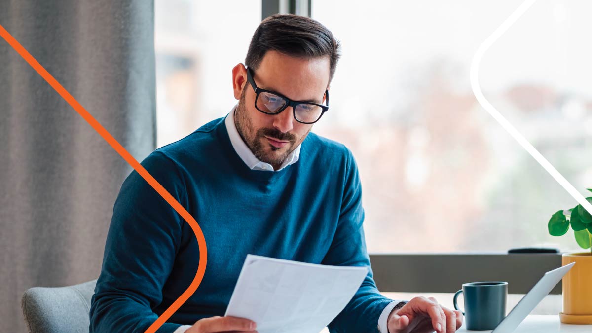 Man in blue sweater working on laptop