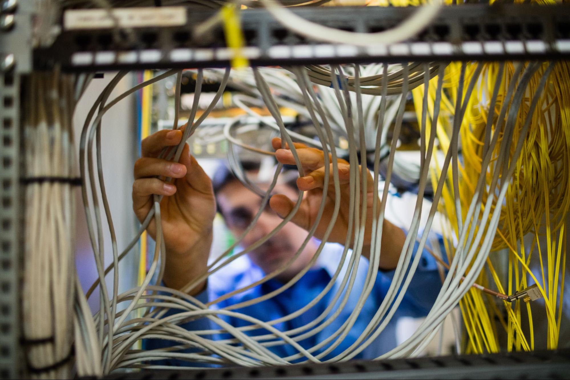 Person working with white networking cables